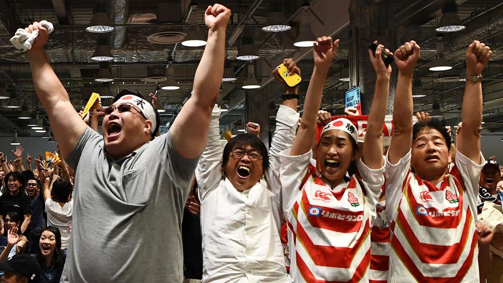Sweet victory: Japan fans revel in their country's win yesterday at the 'fanzone' area in Tokyo PICTURE: GETTY