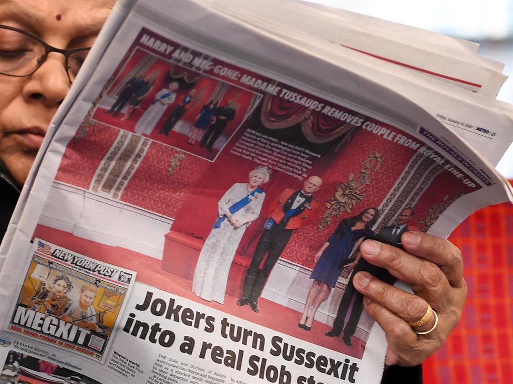 Big news: A woman reads the Metro on a London train this morning as the latest royal crisis unfolds PICTURES: EPA/AP/REX