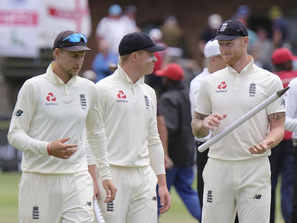 Teamwork: England's captain Joe Root, left, Ollie Pope and Ben Stokes, right, leave the field of play after winning the third Test