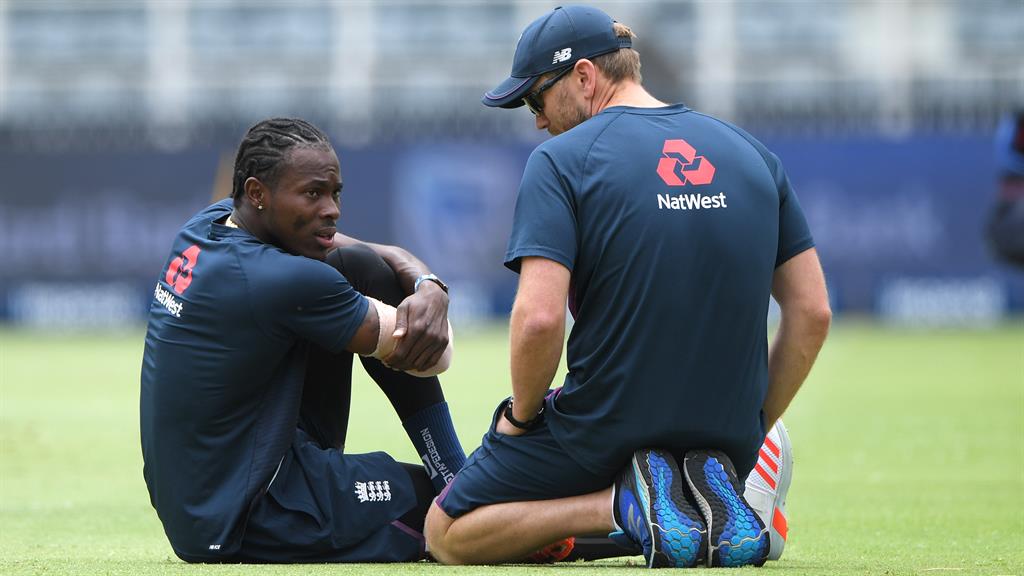 Down and out: Archer chats with physio Craig de Weyman during today's warm-up