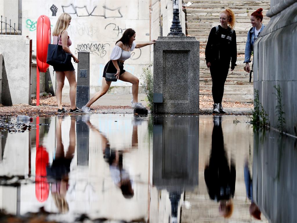 Water feature: Visitors to the Albert Embankment in London contend with a large puddle PICTURE: PA